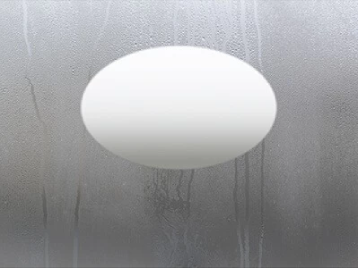 An oval-shaped defogger at the center of a mirror.